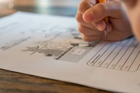طالب يجيب عن ورقة اختبار على مقعده في قاعة الامتحان